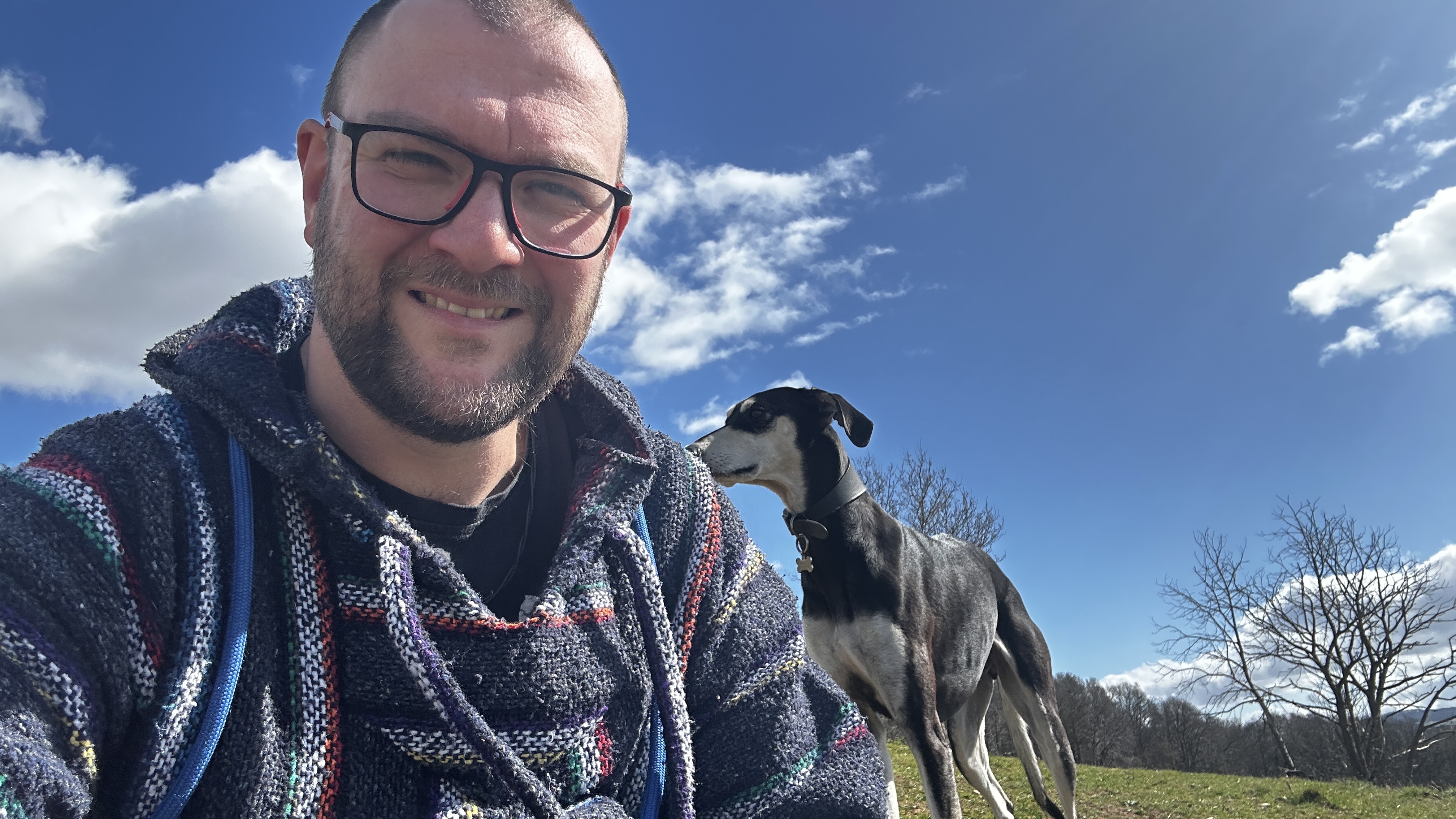 Joby Malkin outdoors on a hillside walk with his lurcher.